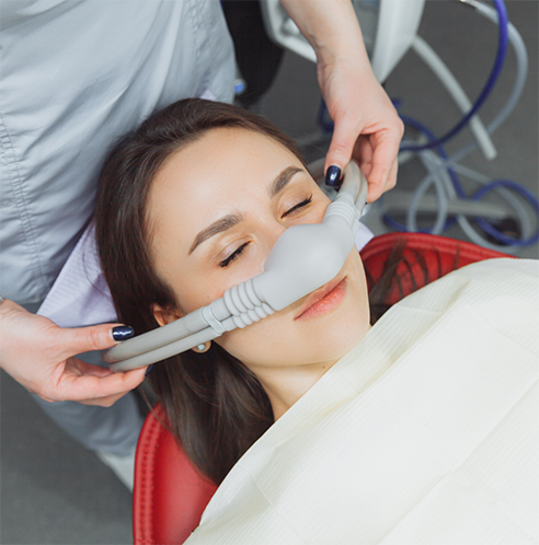 Female patient having nasal mask placed for sedation dentistry