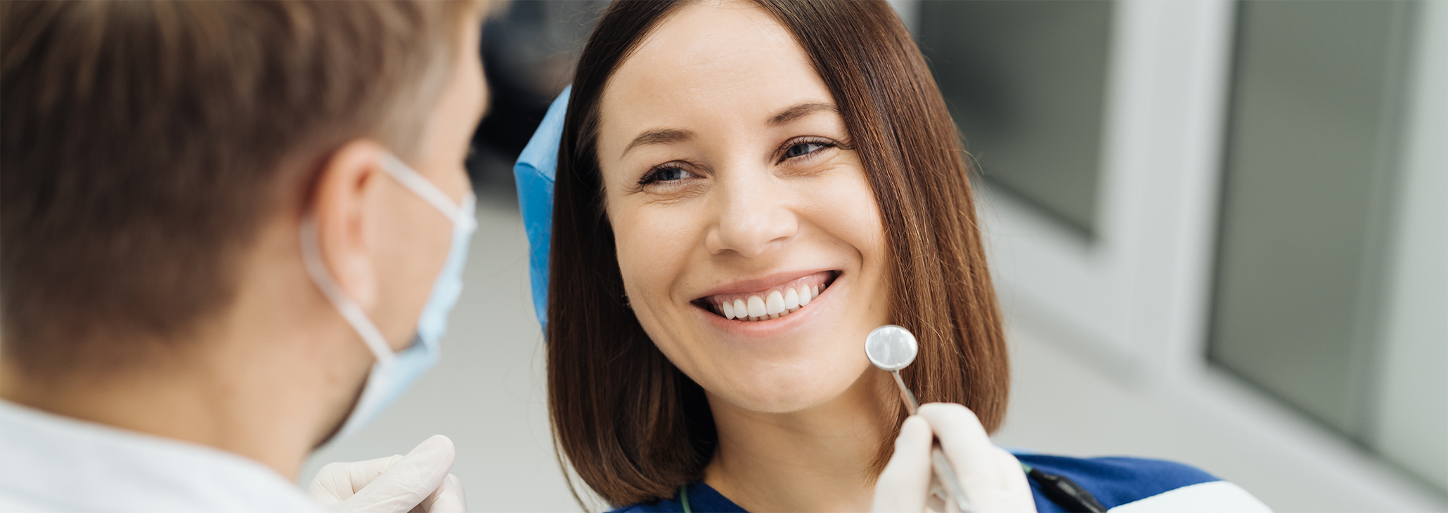 Female patient having teeth examined with dental mirror