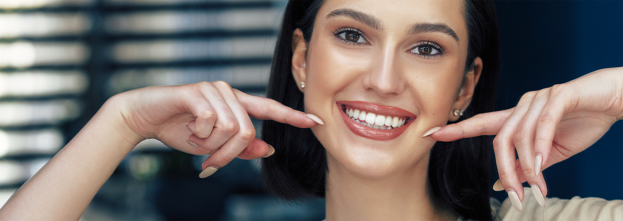 Close up of woman pointing to her smile