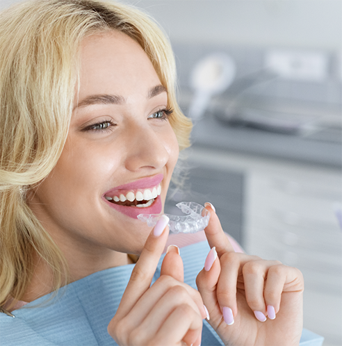 Close up of female dental patient putting in clear aligner