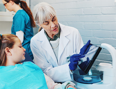 Female dentist showing patient an X-ray