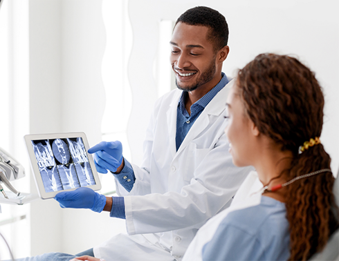 Dentist showing patient an X-ray on a tablet