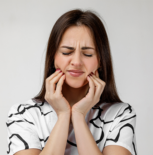Woman with oral pain rubbing jaw