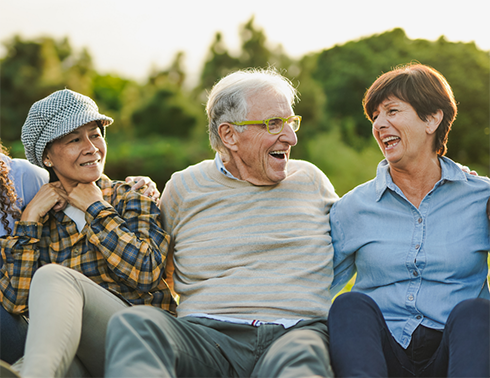 Three people in a row sitting and smiling at each other