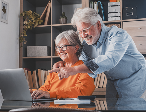Senior man and woman looking at laptop
