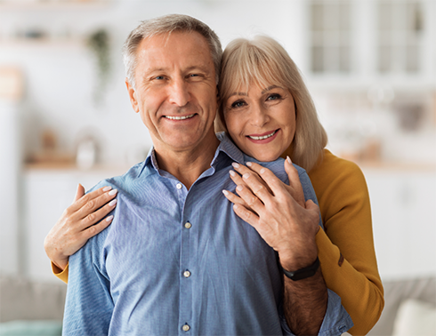 Man being hugged from behind by woman
