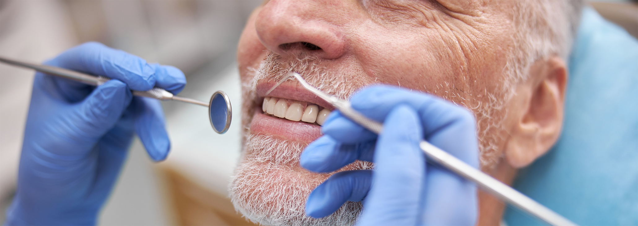 Close up of older man being treated by dentist