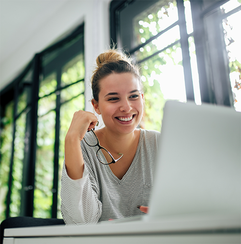 Woman holding glasses and looking at laptop
