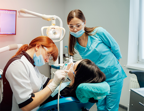 Two female dentist treating a female patient