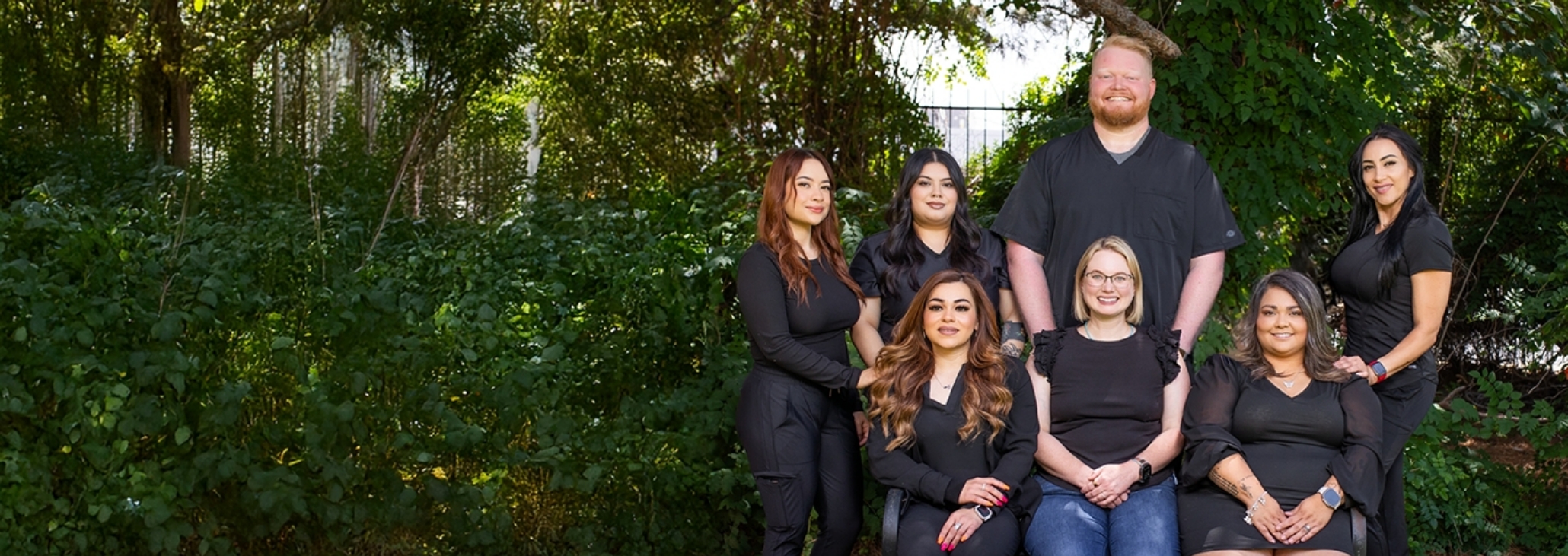 Midland dental team gathered outside in front of fence
