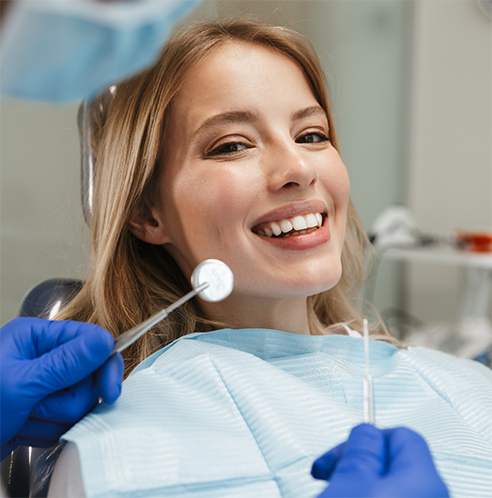 Woman leaning back in dental chair smiling