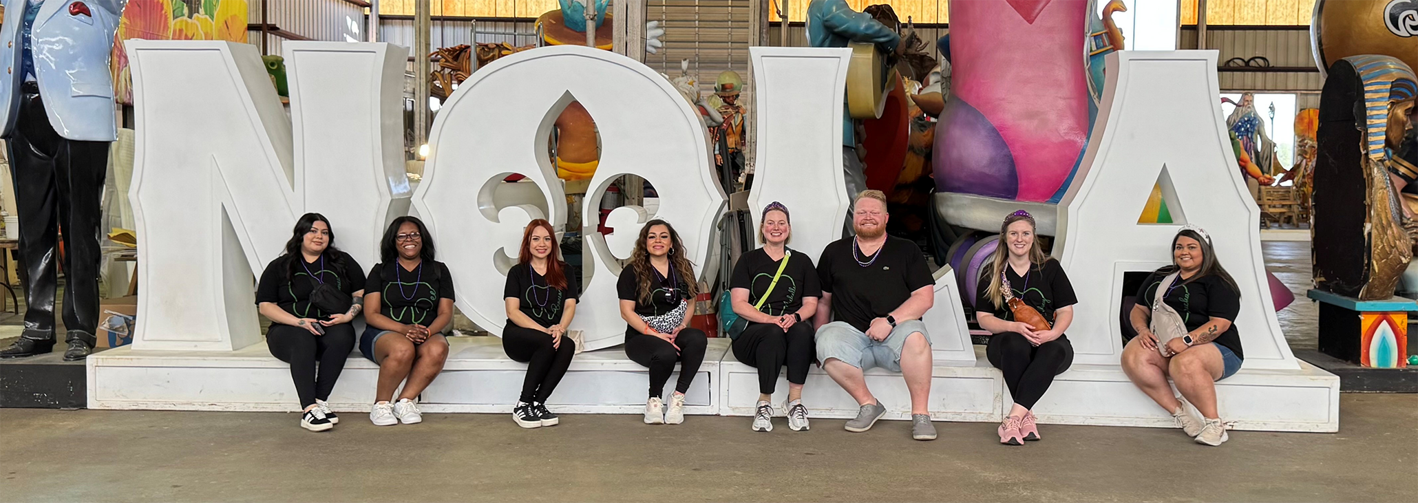 Dental team members sitting in front of giant letters