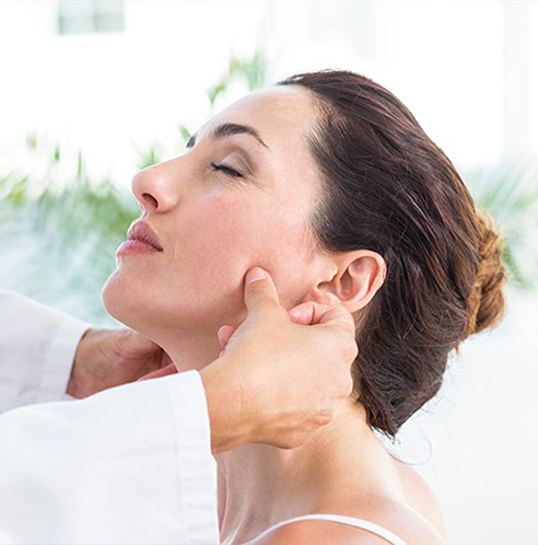 Woman with eyes closed having dentist feel jaw joints