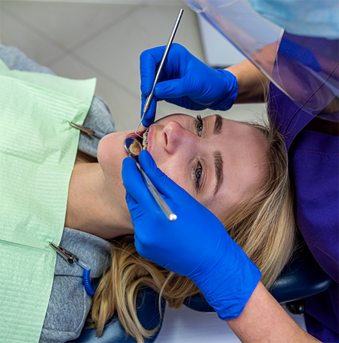 Woman with braces having teeth examined by dentist