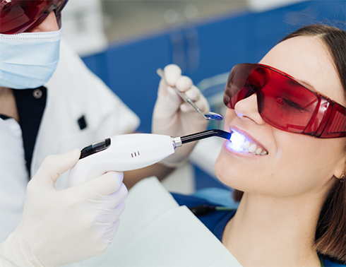 Woman having teeth whitened in office
