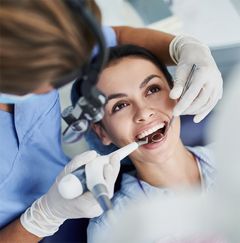 Female patient having teeth examined by dentist