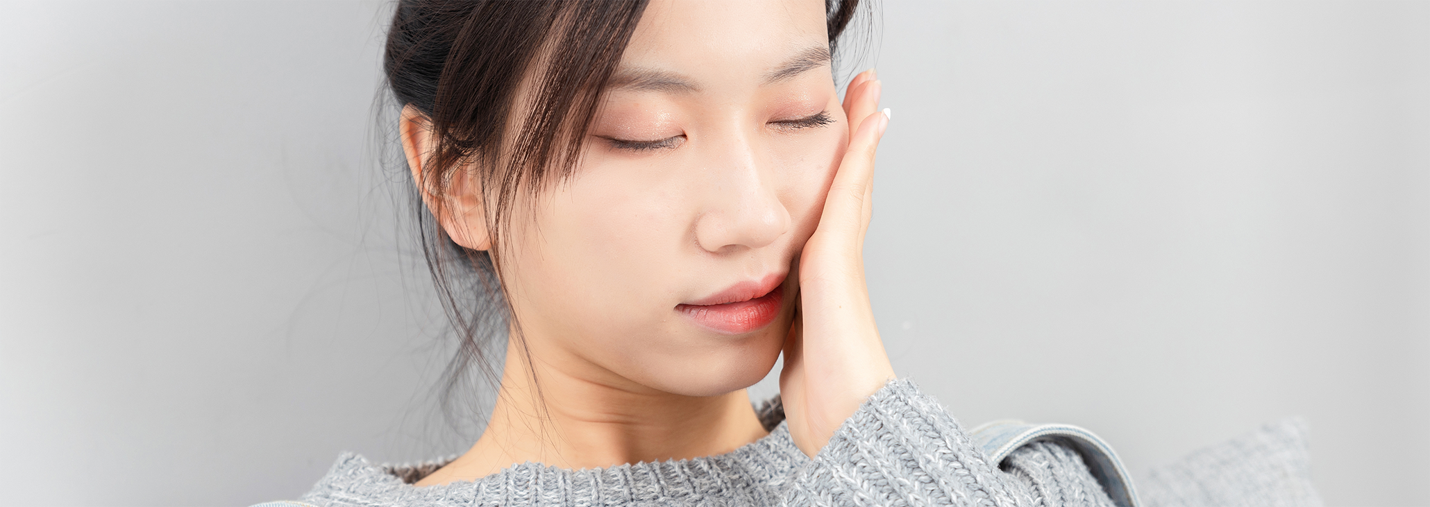 Close up of woman rubbing her jaw in pain