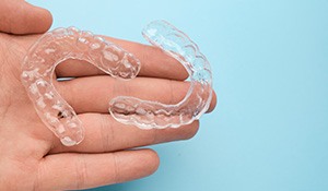 closeup of hand holding clear aligners