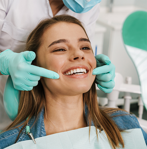 Dentist pulling back patient's lips to show their smile