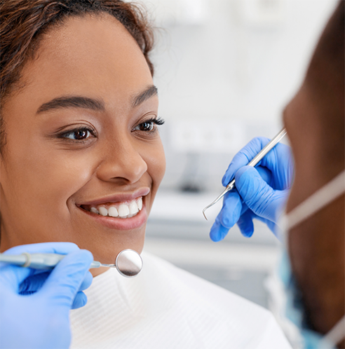 Woman smiling at dentist during dental cleaning