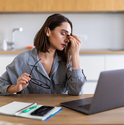Stressed woman taking off glasses and rubbing bridge of nose